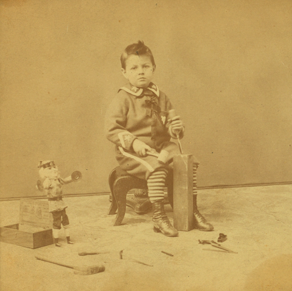 Little_boy_with_a_block_of_wood_carving_tools_and_a_doll_by_Lamprey_M._S._Maurice_S..png.35bda1605d424755067f7b233299aeed.png